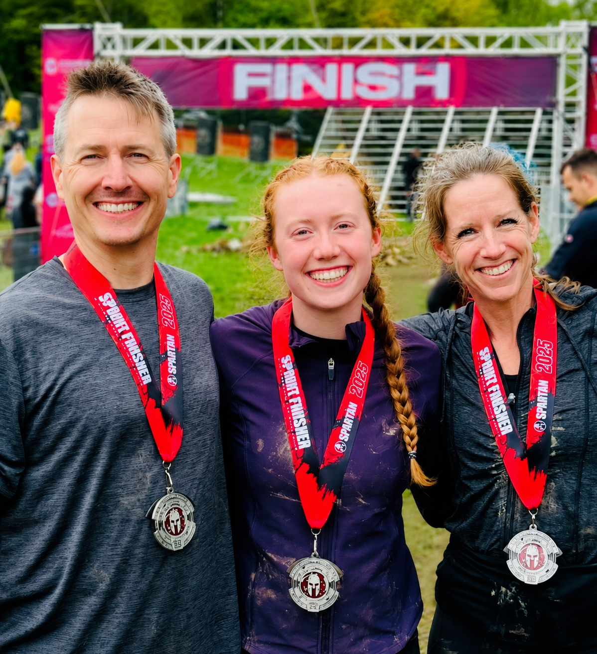  3 OCR Academy members happy, wearing medals at the Spartan Race finish line.
